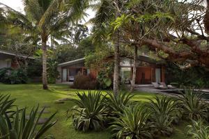 una casa con jardín y palmeras en Umah Tampih Luxury Private Villa - CHSE Certified, en Ubud