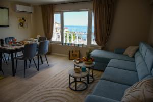 a living room with a blue couch and a table at Marina Elegance Apartments in Balchik