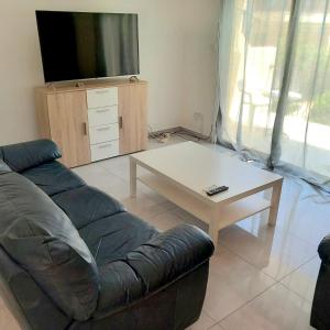 un salon avec un canapé et une table basse dans l'établissement Cydonia Gardens Maisonette with shared pool, à Limassol