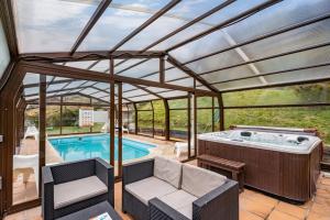 a pool house with a hot tub and a patio at Posada Real Pajares in Pajares