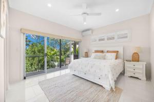 UranganBeachfront Luxury with Ocean Views and Alfresco Dining的一间带床和窗户的白色卧室