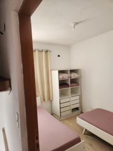 ベルチオガにあるConforto e facilidade em Bertioga praia centroのベッド1台とクローゼットが備わる小さな客室です。