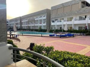 a building with a swimming pool in front of a building at Cecilia Resort in Hurghada +5 photos