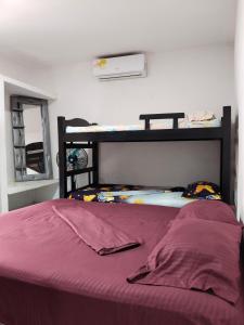 a bed in a room with a purple bedspread at LA MEDELLIN HOSTAL in Cartagena de Indias