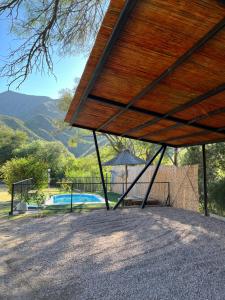 a wooden pavilion with a swimming pool and mountains at Casa Lalina in Laprida