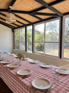 a table with plates and glasses on top of it at Casa Lalina in Laprida +16 photos