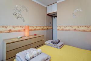 a small bedroom with a yellow bed and a cabinet at 6RoomS BALATON-HÉVÍZ in Hévíz