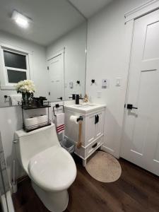 ein weißes Badezimmer mit Toilette und Waschbecken in der Unterkunft LF Guesthouse in Nanaimo + 18 Fotos