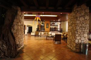 ein Wohnzimmer mit Steinwänden und ein Wohnzimmer mit Stühlen in der Unterkunft Hotel Maya Tucan in Palenque