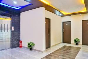 KharadiSuper Collection O Eon Inn Near Pune Airport的一座空的大厅,里面有两个盆栽植物