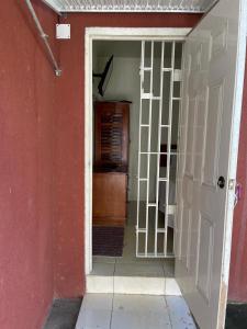 an open door to a room with a red wall at Paradise place small studio in Discovery Bay