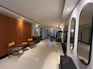 Zimmer mit einem Flur mit Stühlen und einem Tisch in der Unterkunft 2 Suítes, até 4 pessoas, Piscina e Churrasqueira - Praia do Forte! in Cabo Frio + 41 Fotos