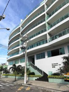 ein großes weißes Gebäude mit einer Treppe davor in der Unterkunft 2 Suítes, até 4 pessoas, Piscina e Churrasqueira - Praia do Forte! in Cabo Frio