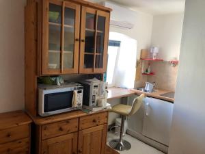 a kitchen with a microwave and a counter with a chair at Appartement Studio 2 Punat Insel Krk in Punat