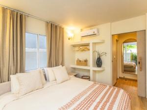 een slaapkamer met een groot wit bed en een raam bij Studio room with private garden in Center Sathorn in Bangkok