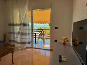 Una sala de estar con una mesa y un balcón. en Gridi's Coastal Escape, en Golem