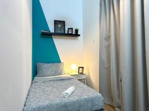 a small bedroom with a bed with a blue wall at delightful Partition Room Barsha Heights Tecom in Dubai