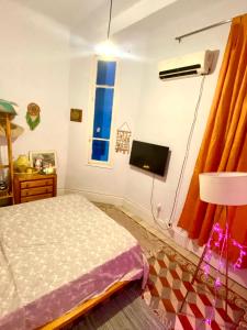 a bedroom with a bed and a tv on the wall at Joli appartement in Tunis