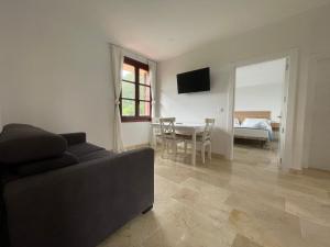 a living room with a couch and a dining room at La Casona Otañes HABITACIONES & APARTMENTS CASTRO URDIALES in Otañes