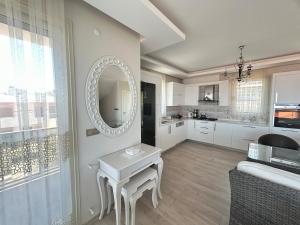 cocina blanca con mesa y espejo en Villa Panorama, en Cesme