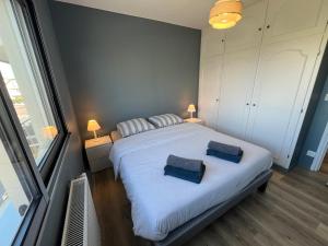 een slaapkamer met een groot wit bed met twee kussens bij Le Grand Large Front de Mer in Le Touquet-Paris-Plage