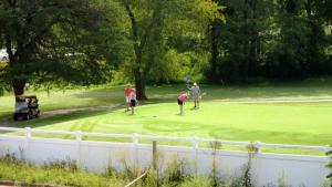 un grupo de personas jugando golf en un putting green en American Motel - Lenoir, en Lenoir