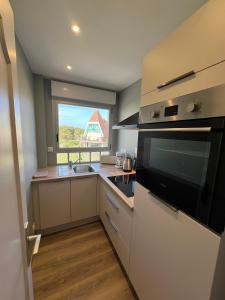 een keuken met een spoelbak en een magnetron bij Le Grand Large Front de Mer in Le Touquet-Paris-Plage +7 foto's