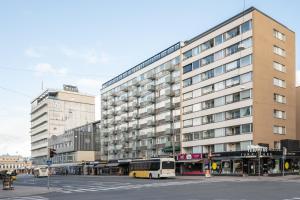 a bus parked in front of a large building at SELF-SERVICE penthouse studio in the heart of Turku! in Turku