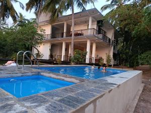 a swimming pool in front of a house at Eagle Wilpattu Resort in Wilpattu