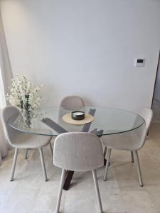 un tavolo di vetro con due sedie e un vaso di fiori di City Chic stade&centre Princesse a Casablanca