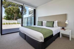 a bedroom with a large bed and a large window at 381 Cremorne in Melbourne