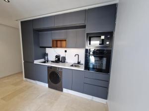una cucina con armadi grigi e lavatrice e asciugatrice di City Chic stade&centre Princesse a Casablanca