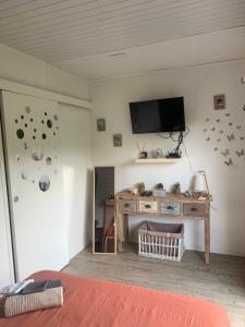 a bedroom with a tv on the wall and a desk at T2 Beausoleil in Les Abymes