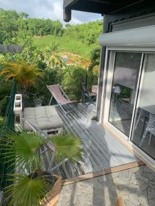 a patio with a couch and chairs on a house at T2 Beausoleil in Les Abymes