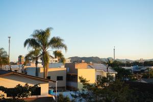 a city skyline with a palm tree and buildings at Pousada Paraná in Penha
