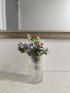 un vaso di vetro con fiori davanti a uno specchio di Entire 2 Bedroom Flat Lincoln a Lincoln