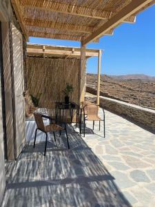 a patio with a table and chairs on a roof at Darsi suites Kythnos in Kithnos