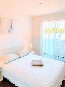 a white bedroom with a white bed with a window at Western Monroe in Los Angeles