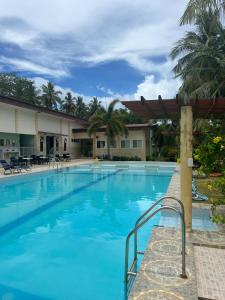a large swimming pool with blue water at Reef Waters Resort in Pilar