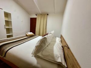 a bedroom with a large bed with white sheets at turisolcor atacama in San Pedro de Atacama