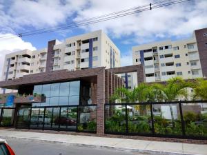 un edificio in mattoni di fronte a due edifici alti di APT 2 QUARTOS c AR, PISCINA E VARANDA Pertinho da Praia de Aruana ad Aracaju