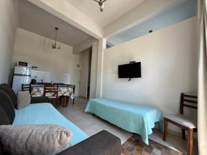 a living room with a couch and a tv on the wall at Ak´Para in Tandil