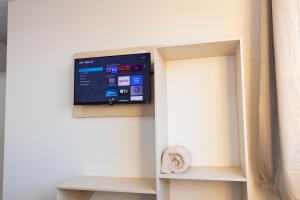 a flat screen tv on a wall in a room at Pousada Paraná in Penha