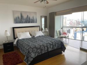a bedroom with a bed and a view of a city at Book in Miraflores - Lima in Lima