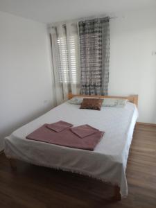 a bedroom with a bed with two towels on it at Yellow hill Batinac in Ćuprija +8 photos