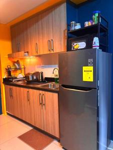 a kitchen with a stainless steel refrigerator and a sink at SLY Staycation at Shore Residences Mall of Asia in Manila