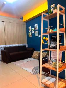 a living room with a couch and a shelf at SLY Staycation at Shore Residences Mall of Asia in Manila