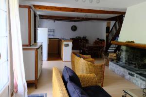 a living room with a table and chairs and a kitchen at Au Gré des Saisons - 4 chambres in Gère-Belesten