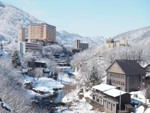 Una ciudad cubierta de nieve con edificios y un río. en 山荘 ひとやね -Sansou Hitoyane-, en Sapporo