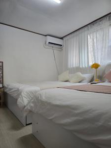 a white bedroom with two beds and a window at Daechi, Good stay,gang nam in Seoul +47 photos